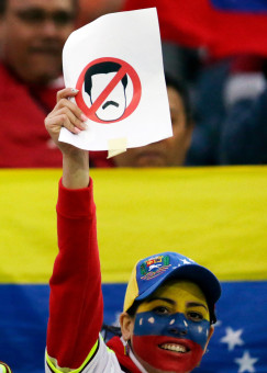 A fan of Venezuela waves a banner with the image of Venezuela's President Nicolas Maduro prior a Copa America Group A soccer match between Venezuela and Peru at the Elias Figueroa stadium in Valparaiso, Chile, Thursday, June 18, 2015. (AP Photo/Jorge Saenz)