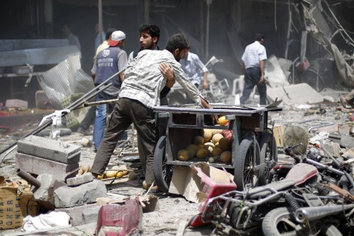 Syrian men react as they stand amid the rubble following air strikes by Syrian government forces on a marketplace in the rebel-held area of Douma, east of the capital Damascus, on August 16, 2015. At least 70 people were killed and 200 people were injured, with the death toll -most of them civilians- likely to rise as many of the wounded were in serious condition, the Syrian Observatory for Human Rights said. AFP PHOTO / SAMEER AL-DOUMY  SYRIA-CONFLICT