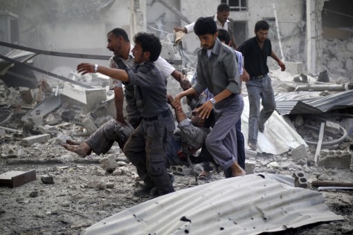 Syrian emergency personnel carry a wounded man following air strikes by Syrian government forces on a marketplace in the rebel-held area of Douma, east of the capital Damascus, on August 16, 2015. At least 70 people were killed and 200 people were injured, with the death toll -most of them civilians- likely to rise as many of the wounded were in serious condition, the Syrian Observatory for Human Rights said. AFP PHOTO / SAMEER AL-DOUMY  SYRIA-CONFLICT