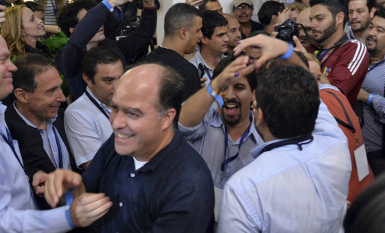 Venezuelan opposition Democratic Unity Movement (MUD) party members celebrate after knowing the first results of the legislative election, at the headquarters in Caracas, on the early morning December 7, 2015. Venezuelan electoral authorities announced that the opposition had won majority in Venezuela legislature.  At L Julio Borges, representative of Primero Justicia mouvement. AFP PHOTO/LUIS ROBAYO / AFP / LUIS ROBAYO