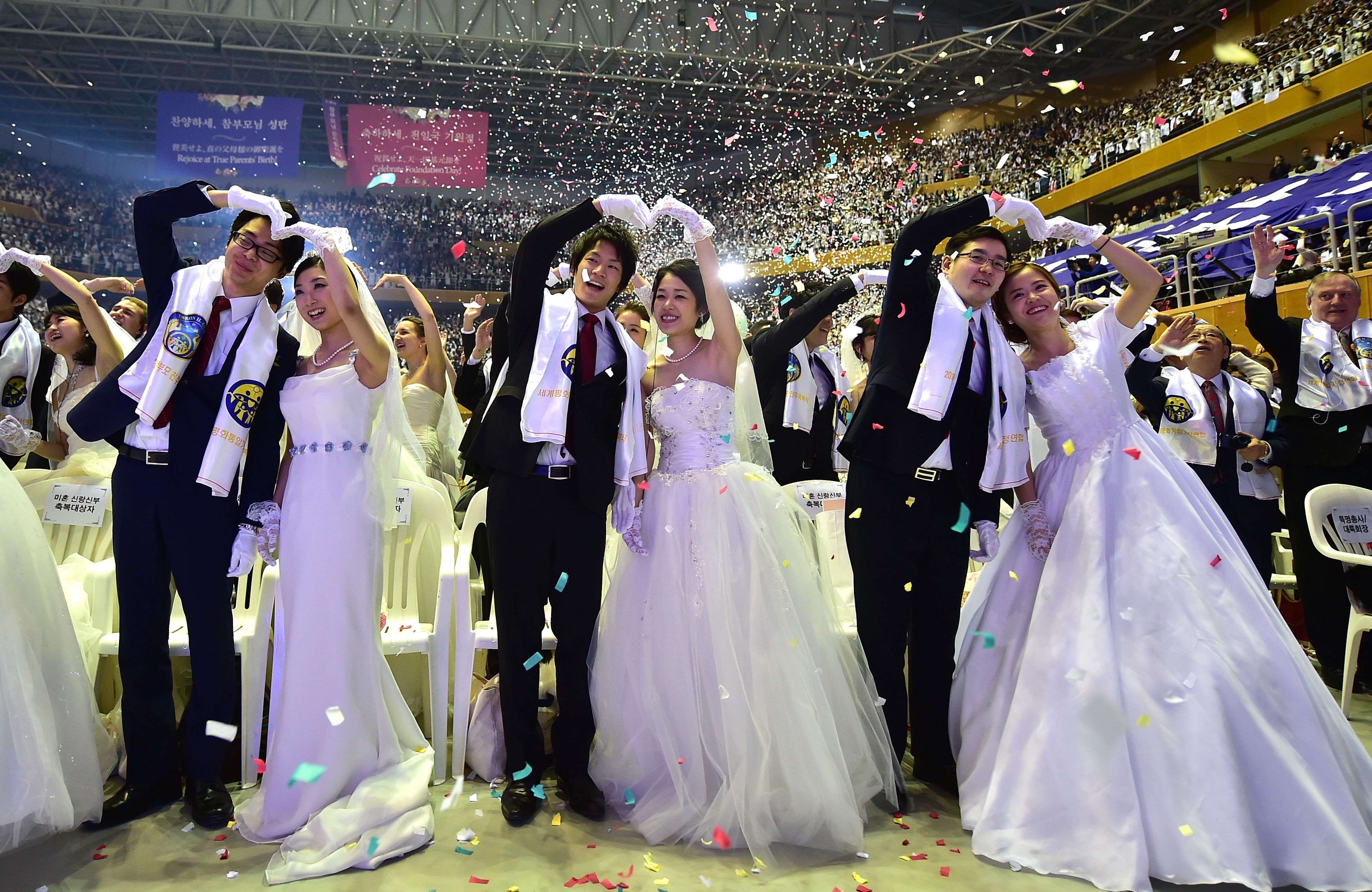 Couples celebrate during a mass wedding held by the Unification Church at Cheongshim Peace World Center in Gapyeong, east of Seoul, on February 20, 2016. Hundreds of couples were married at the South Korean headquarters of the Unification Church. The Unification Church, set up by Sun Myung Moon in Seoul in 1954, is one of the world's most controversial religious organisations, and its devotees are often dubbed "Moonies" after the founder. AFP PHOTO / JUNG YEON-JE SKOREA--RELIGION-UNIFICATION-MARRIAGE