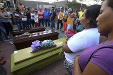 Relatives of dead miners stand next to their coffins during a tribute prior to their burial in Tumeremo in Bolivar state, Venezuela March 16, 2016. REUTERS/Stringer FOR EDITORIAL USE ONLY. NO RESALES. NO ARCHIVE.