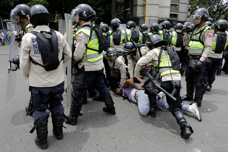 Riot police officers detain a demonstrator during clashes with opposition supporters in a rally to demand a referendum to remove President Nicolas Maduro in Caracas, Venezuela, May 18, 2016. REUTERS/Marco Bello