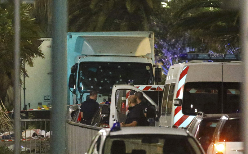 French police forces and forensic officers stand next to a truck July 15, 2016 that ran into a crowd celebrating the Bastille Day national holiday on the Promenade des Anglais killing at least 60 people in Nice, France, July 14.   REUTERS/Eric Gaillard