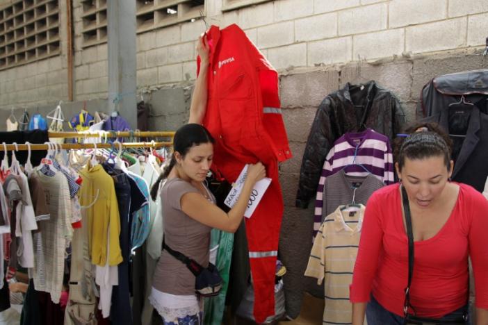A woman carries a PDVSA's overall for sale at a market in Maracaibo, Venezuela September 11, 2016. REUTERS/Jesus Contreras