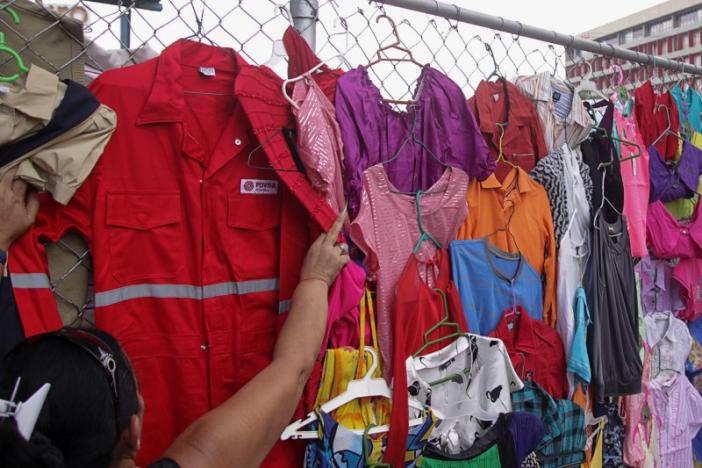 A customer looks at a PDVSA's overalls for sale at a market in Maracaibo, Venezuela September 11, 2016. REUTERS/Jesus Contreras